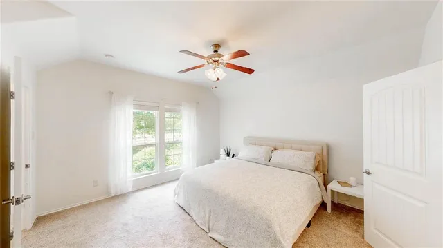 a bedroom with a large bed and a chandelier