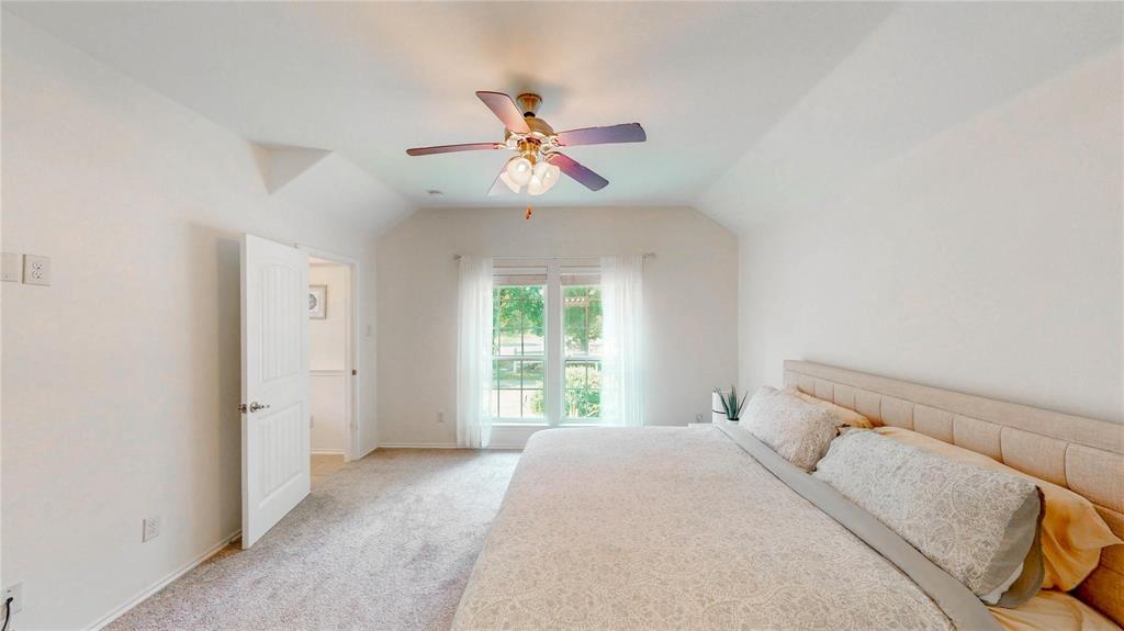 1808 Dr Sanders Road Providence Village, TX 76227 - Photo 16 of 31 a bedroom with a large bed and a chandelier