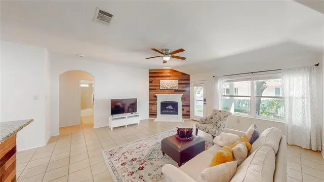 a living room with furniture a fireplace and a flat screen tv