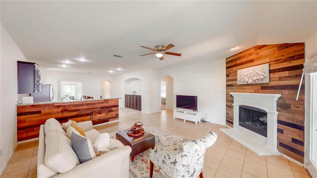 1808 Dr Sanders Road Providence Village, TX 76227 - Photo 20 of 31 a living room with furniture a fireplace and a flat screen tv