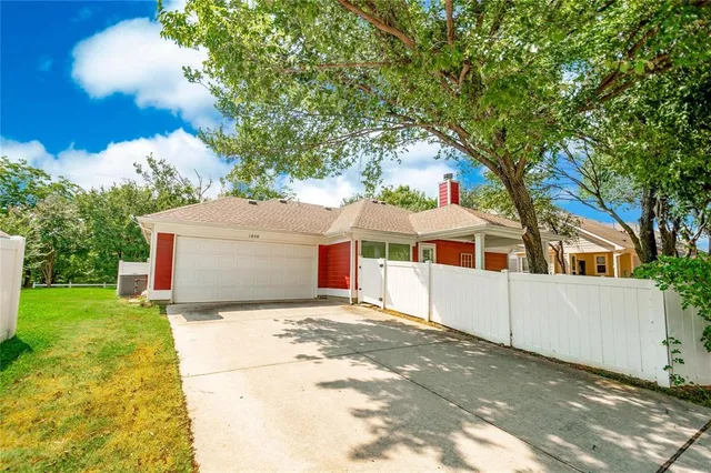 a view of a house with backyard and a tree