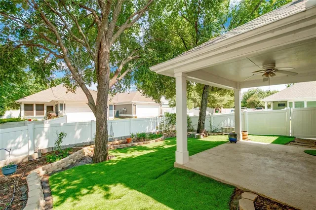 a view of an house with backyard space and a tree