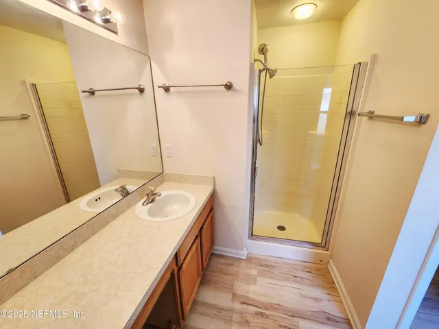 a view of a room with wooden floor and a ceiling fan