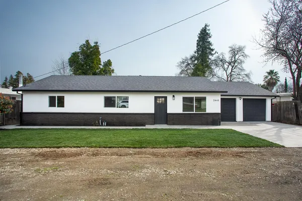 a front view of a house with a garden and yard