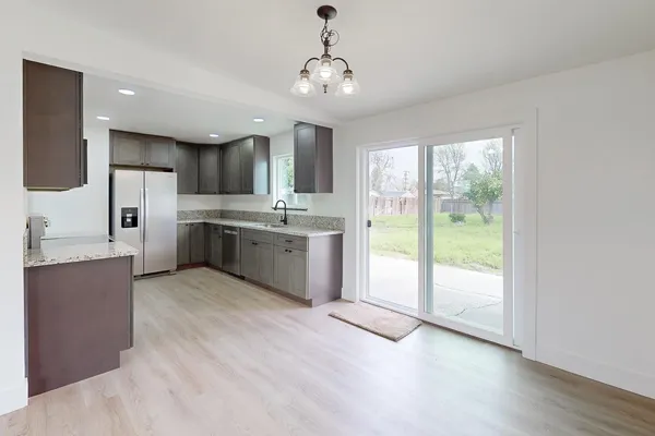 a large kitchen with a window and stainless steel appliances