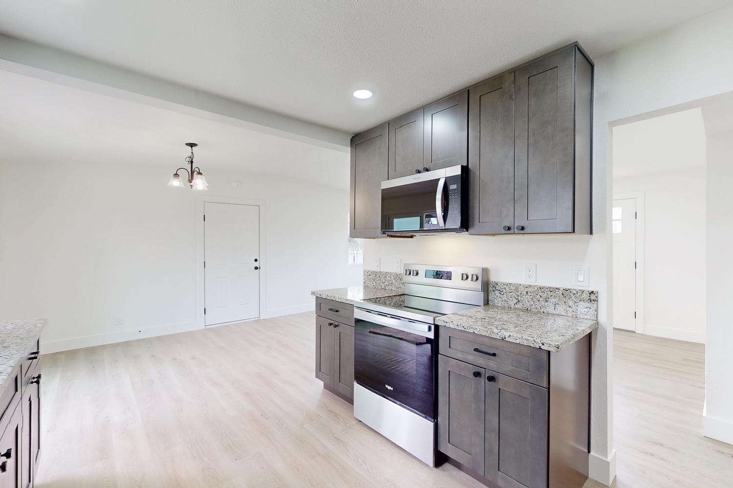 2441 Madrone Street Sutter, CA 95982 - Photo 16 of 47 a kitchen with stainless steel appliances granite countertop a sink stove and cabinets