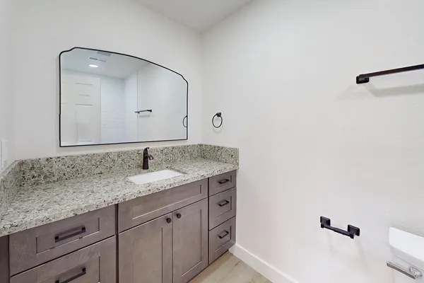 a bathroom with a granite countertop sink and a mirror