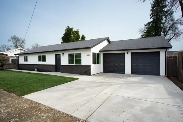 a front view of a house with a yard and garage