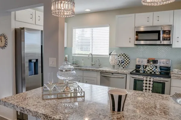a kitchen with stainless steel appliances granite countertop a refrigerator and a stove top oven