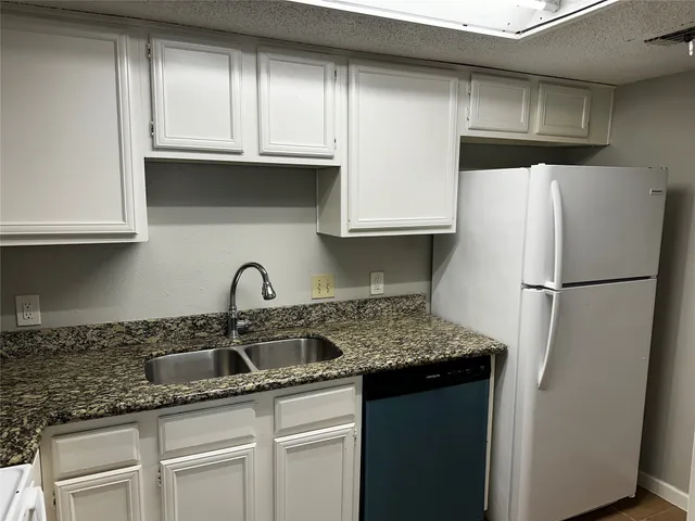 a kitchen with stainless steel appliances granite countertop a refrigerator sink and cabinets