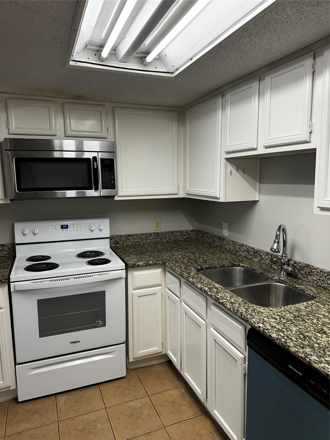 3756 Tanglewilde Street, Unit 8D Houston, TX 77063 - Photo 6 of 14 a kitchen with granite countertop a stove sink and cabinets