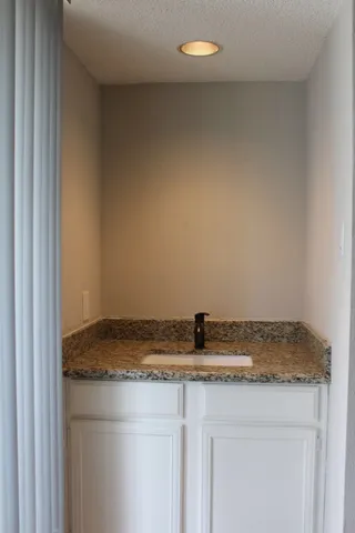 a bathroom with a granite countertop sink and vanity