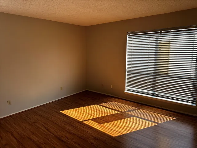 a view of a room with wooden floor and a window