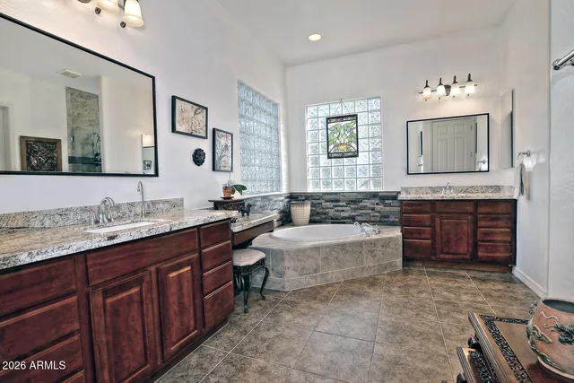 a spacious bathroom with a tub sink and mirror