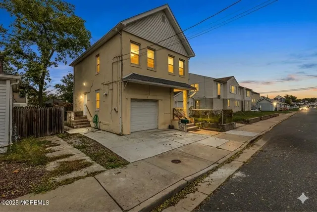a view of a house with a small yard and wooden fence