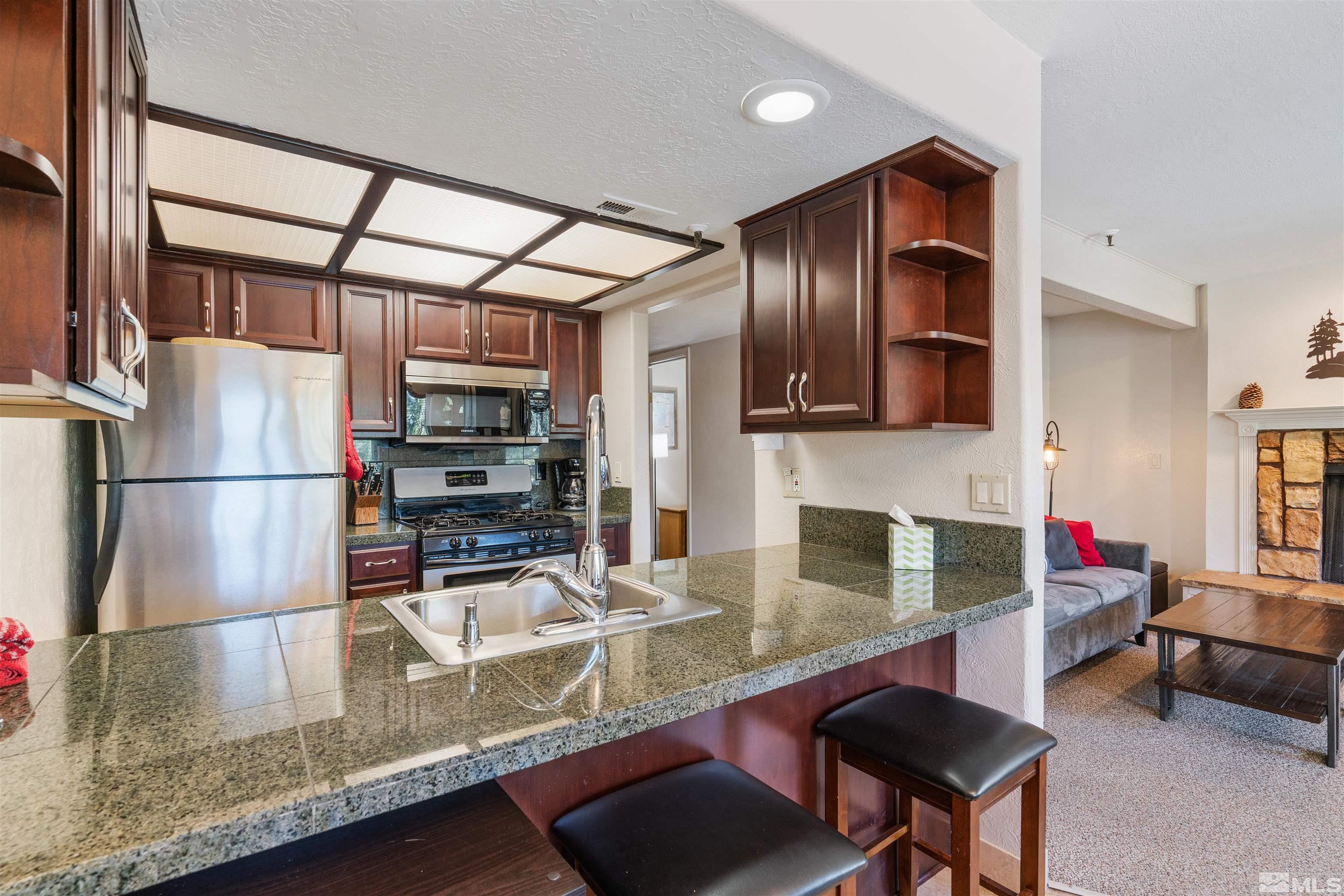 754 Boulder Court, Unit 9 Stateline, NV 89449 - Photo 11 of 38 a kitchen with stainless steel appliances granite countertop a refrigerator and a sink