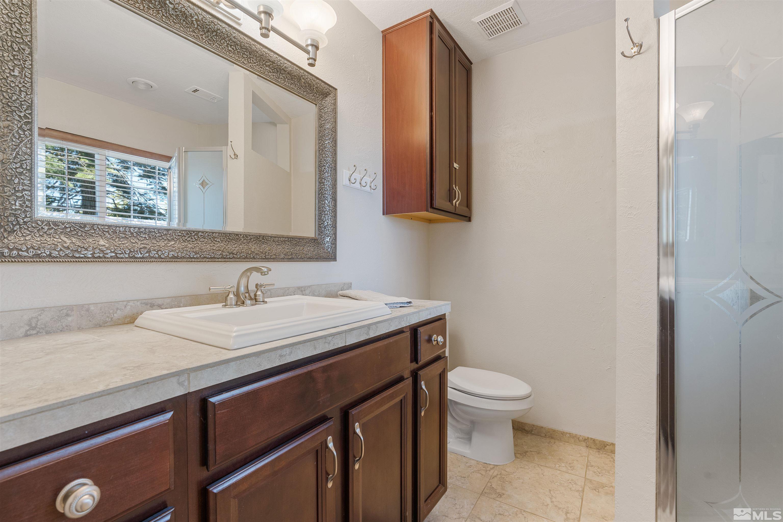 754 Boulder Court, Unit 9 Stateline, NV 89449 - Photo 25 of 38 a bathroom with a granite countertop sink a toilet and a mirror