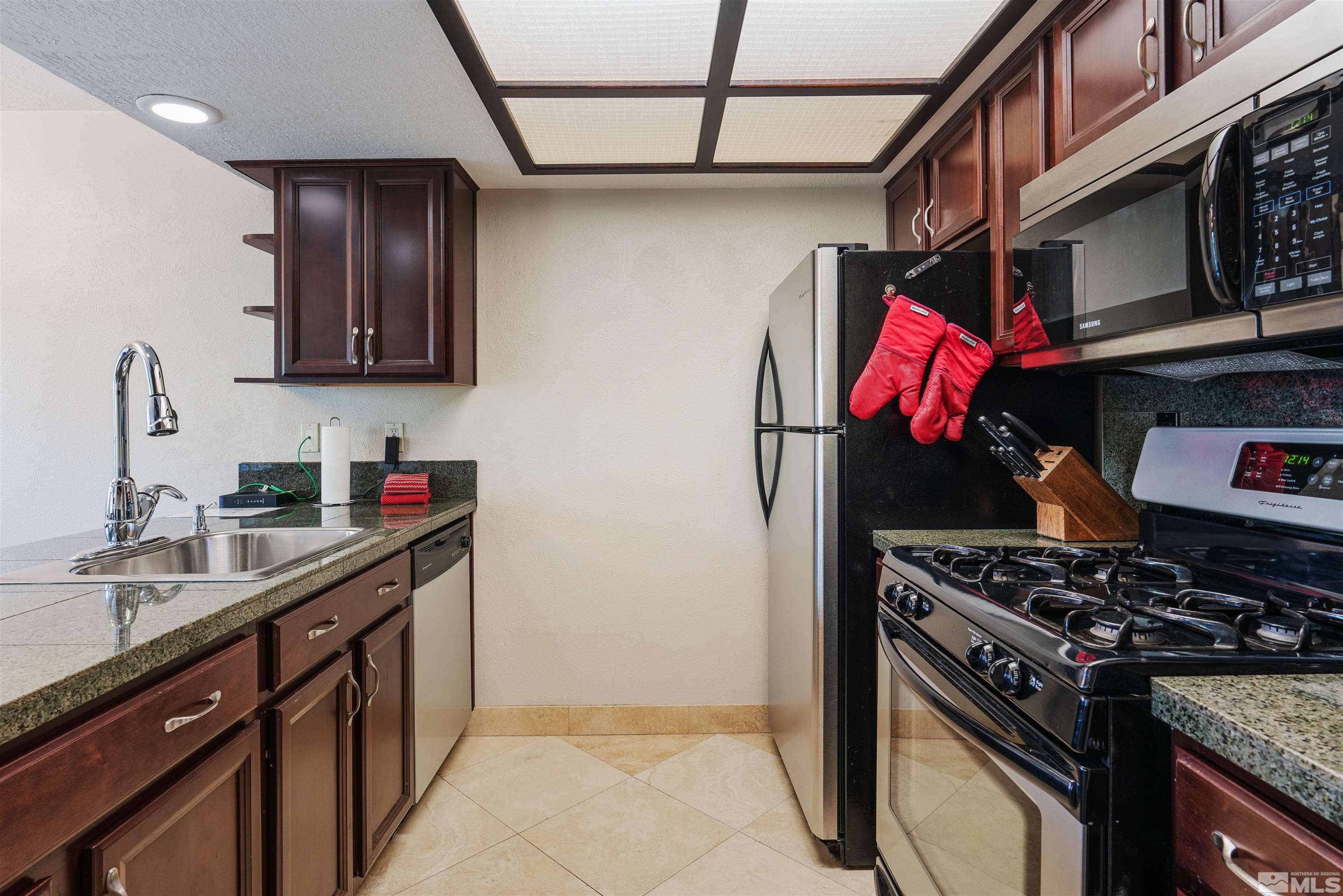 754 Boulder Court, Unit 9 Stateline, NV 89449 - Photo 9 of 38 a kitchen with stainless steel appliances granite countertop a sink stove and refrigerator