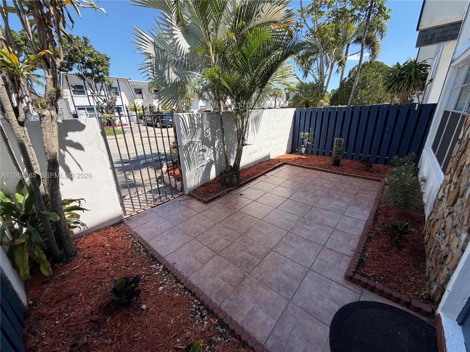 6760 Southwest 40th Street, Unit 41 Davie, FL 33314 - Photo 3 of 51 a view of backyard with large trees and wooden fence