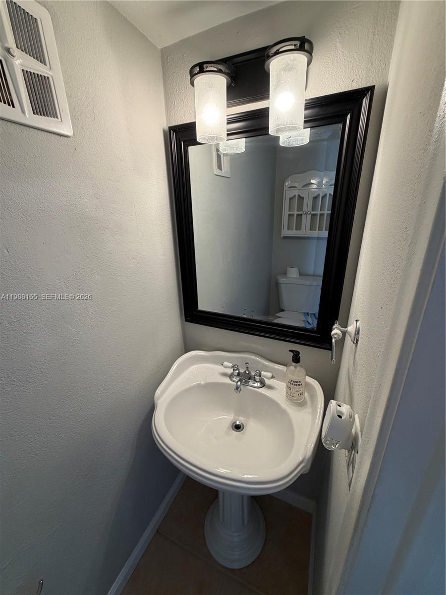 6760 Southwest 40th Street, Unit 41 Davie, FL 33314 - Photo 42 of 51 a bathroom with a sink and mirror