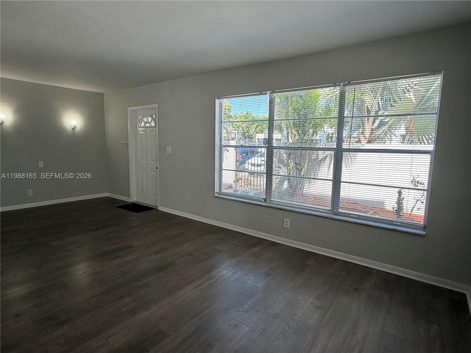 6760 Southwest 40th Street, Unit 41 Davie, FL 33314 - Photo 6 of 51 a view of an empty room with wooden floor and a window