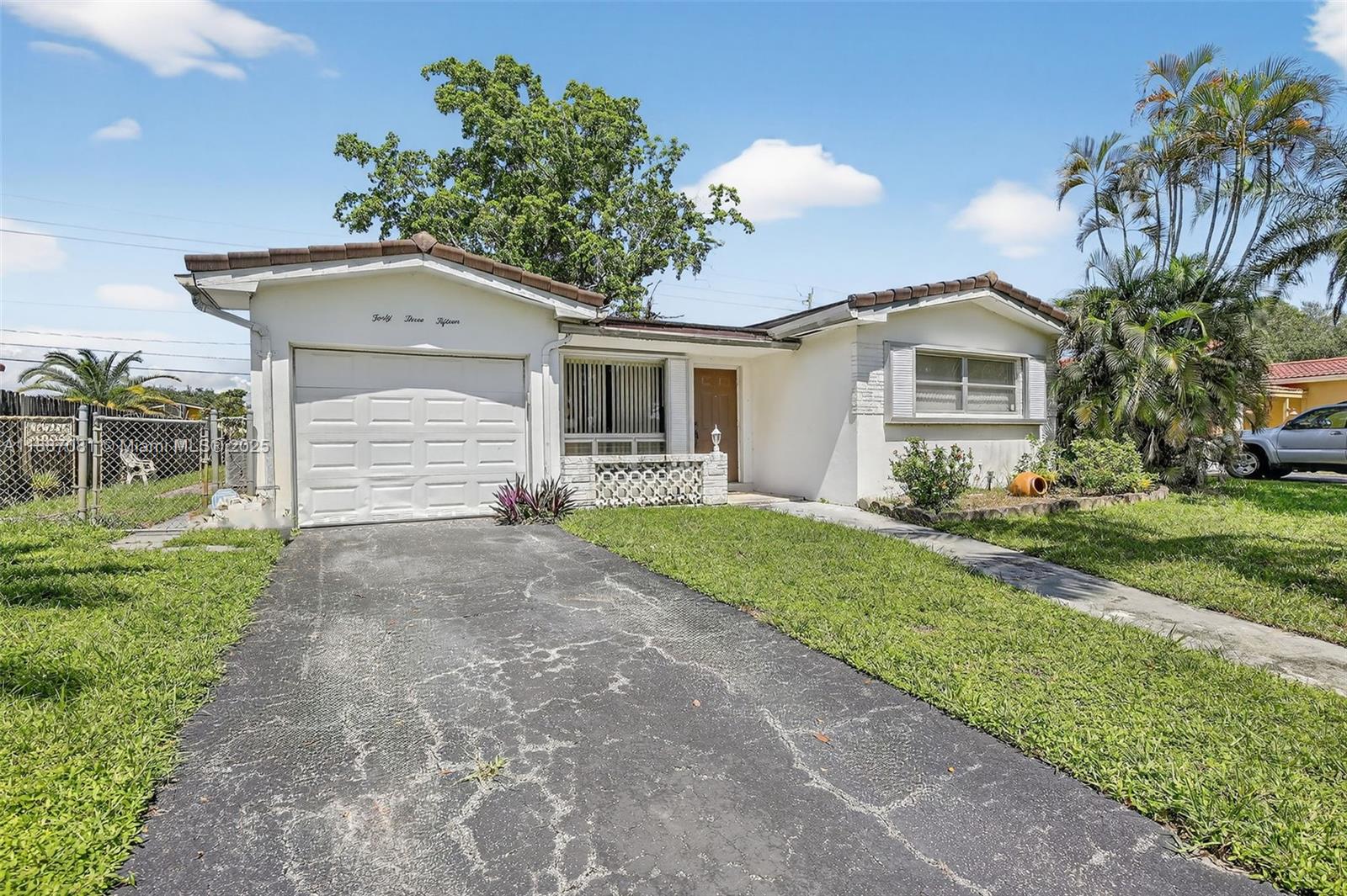 4315 West Park Road Hollywood, FL 33021 - Photo 2 of 24 a front view of a house with a yard and potted plants