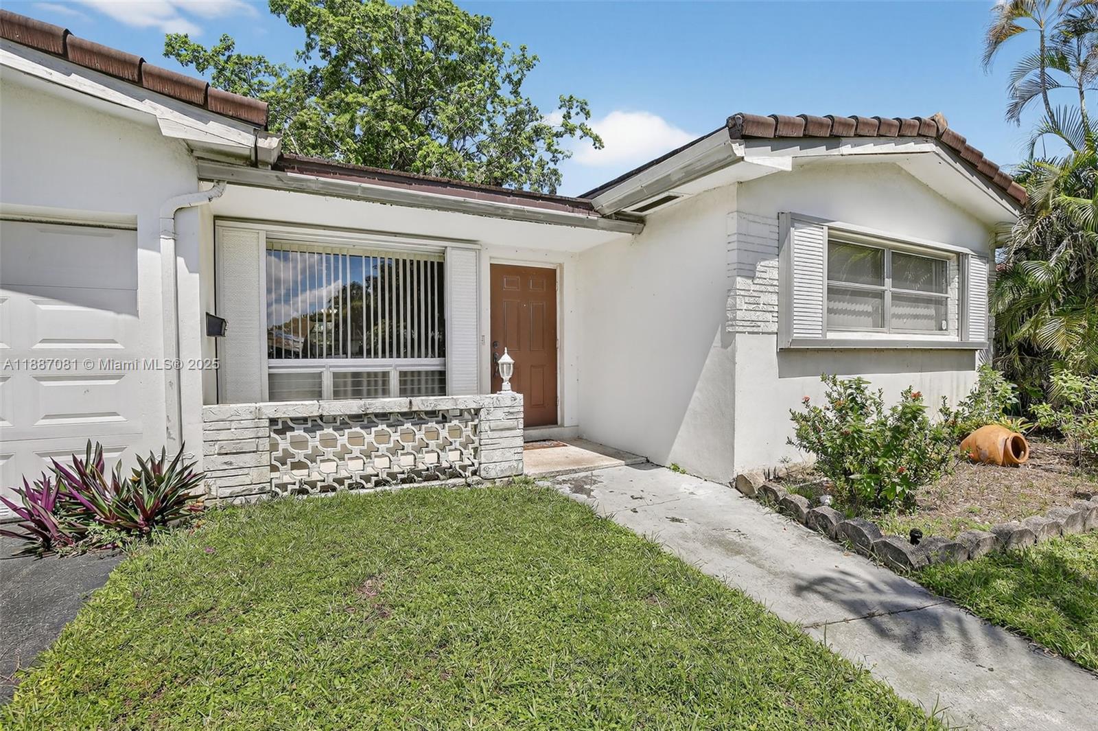 4315 West Park Road Hollywood, FL 33021 - Photo 3 of 24 a front view of a house with a garden