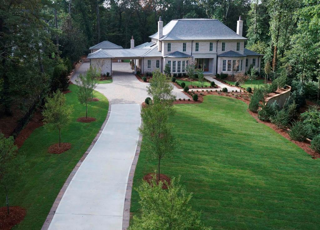 a front view of a house with yard and green space