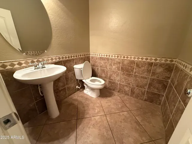 a bathroom with a sink toilet and a mirror