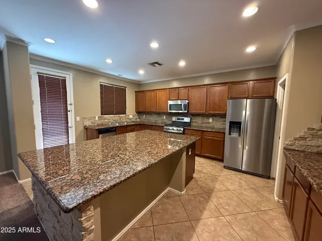 a kitchen with stainless steel appliances granite countertop a refrigerator oven stove a sink and a oven