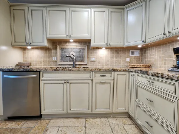 a kitchen with white cabinets and white appliances