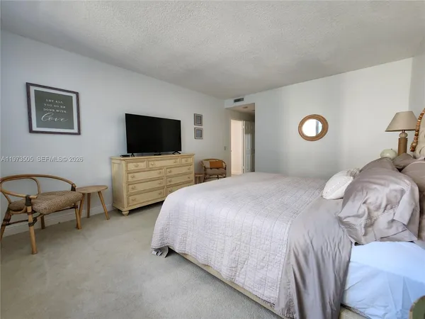 a bedroom with bed and a flat screen tv