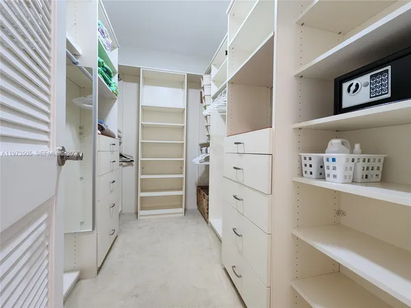 a view of walk in closet with clothes and shoes