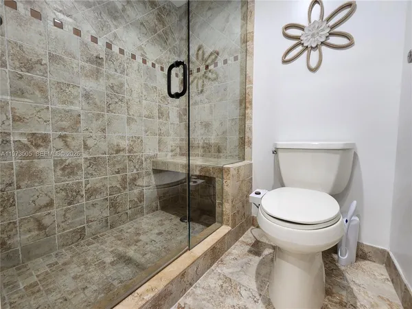 a bathroom with a toilet and a shower