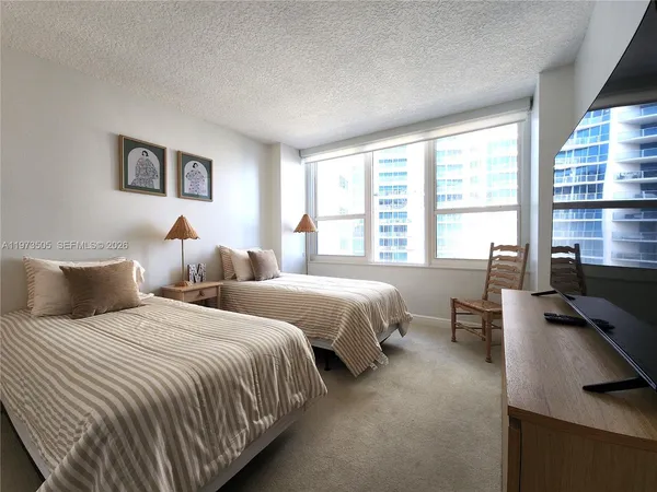 a bedroom with two beds and large window