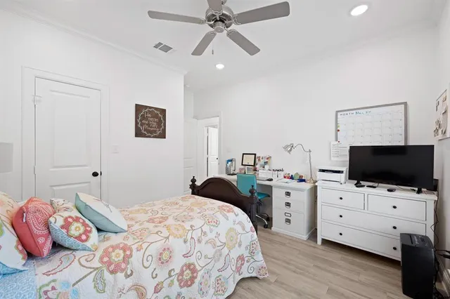 a bedroom with a bed and a flat tv screen on dresser