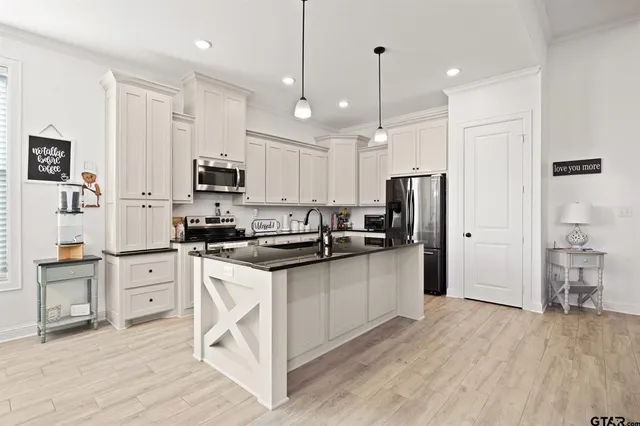 a kitchen with white cabinets and stainless steel appliances