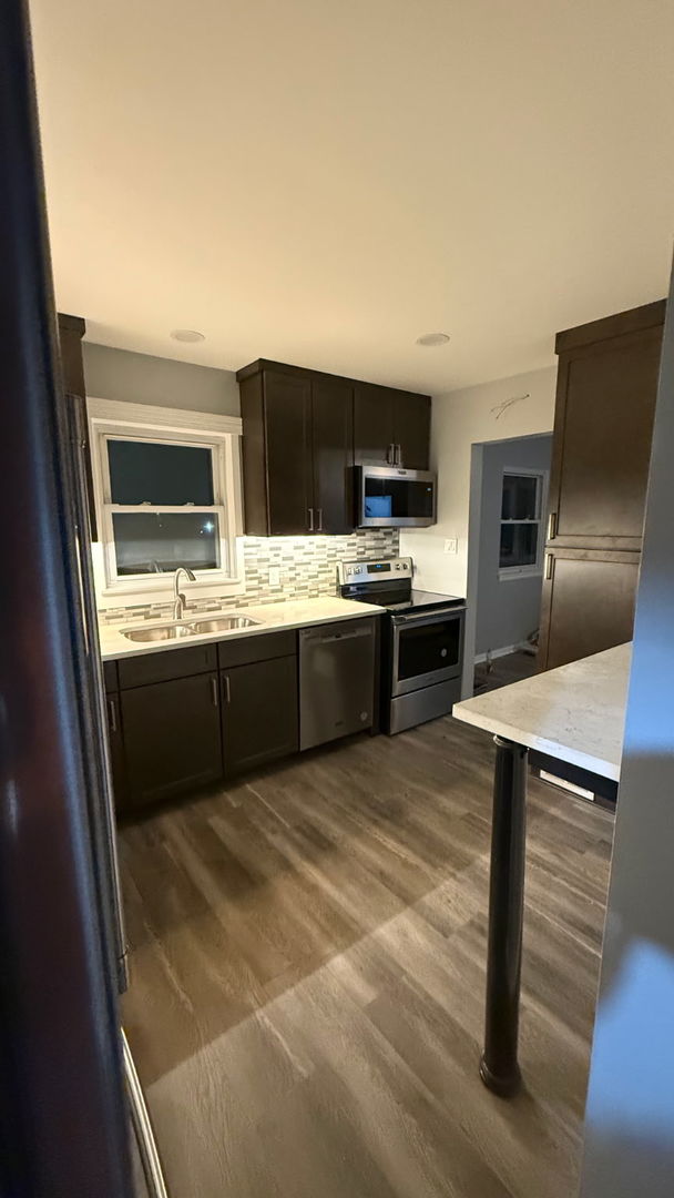 601 East 10th Street Lockport, IL 60441 - Photo 4 of 11 a kitchen with stainless steel appliances a stove a sink and a refrigerator
