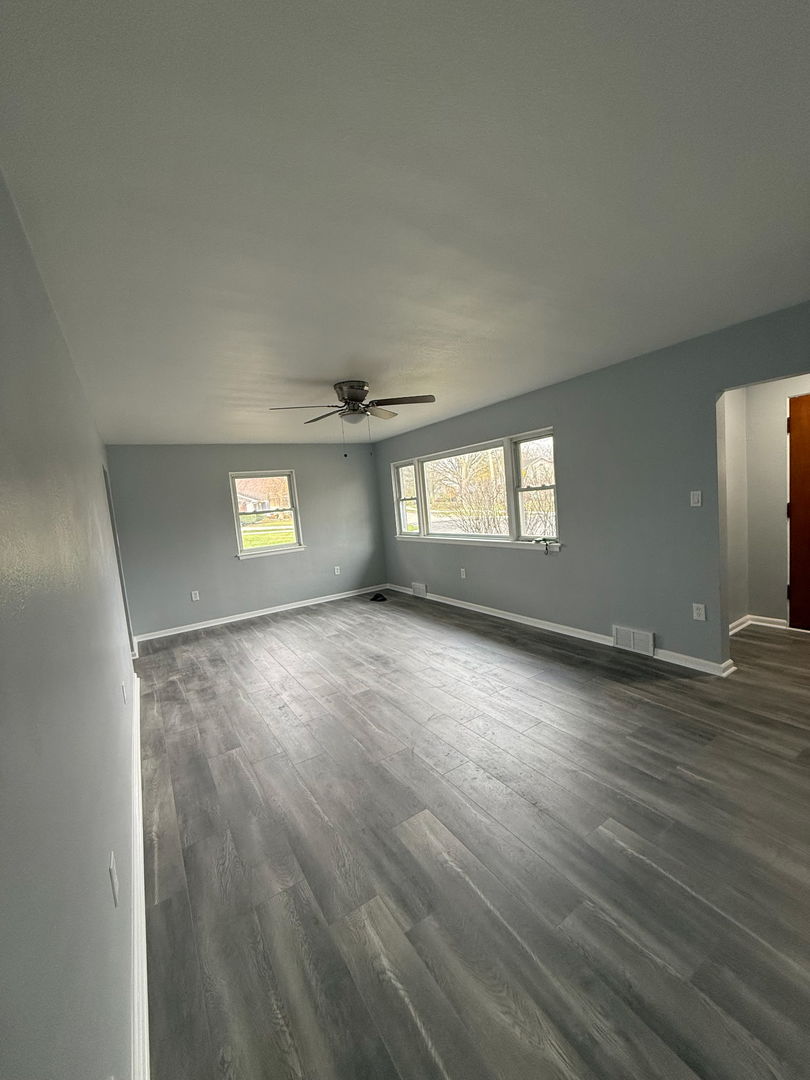 601 East 10th Street Lockport, IL 60441 - Photo 7 of 11 an empty room with wooden floor and windows