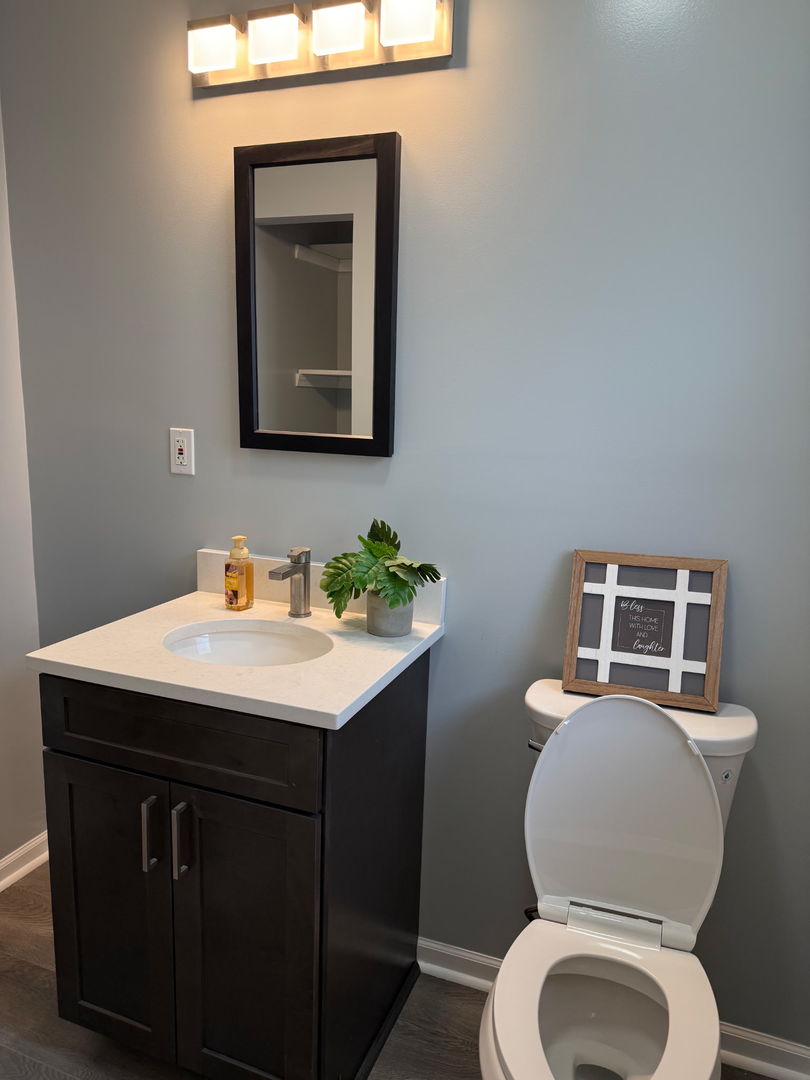 601 East 10th Street Lockport, IL 60441 - Photo 9 of 11 a bathroom with a toilet sink and mirror