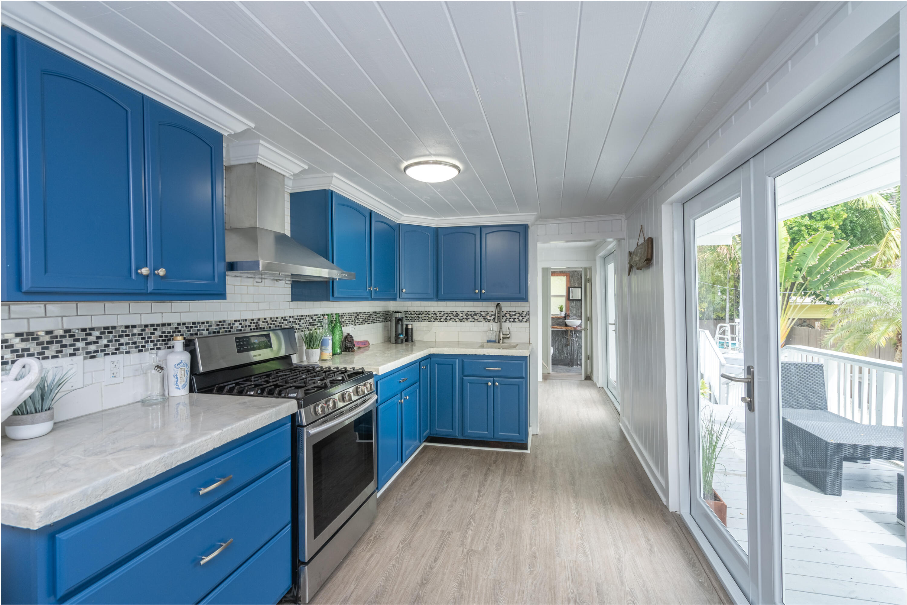 124 South Bay Harbor Drive Key Largo, FL 33037 - Photo 11 of 28 a kitchen with stainless steel appliances granite countertop wooden cabinets a stove top oven a sink and dishwasher with wooden floor