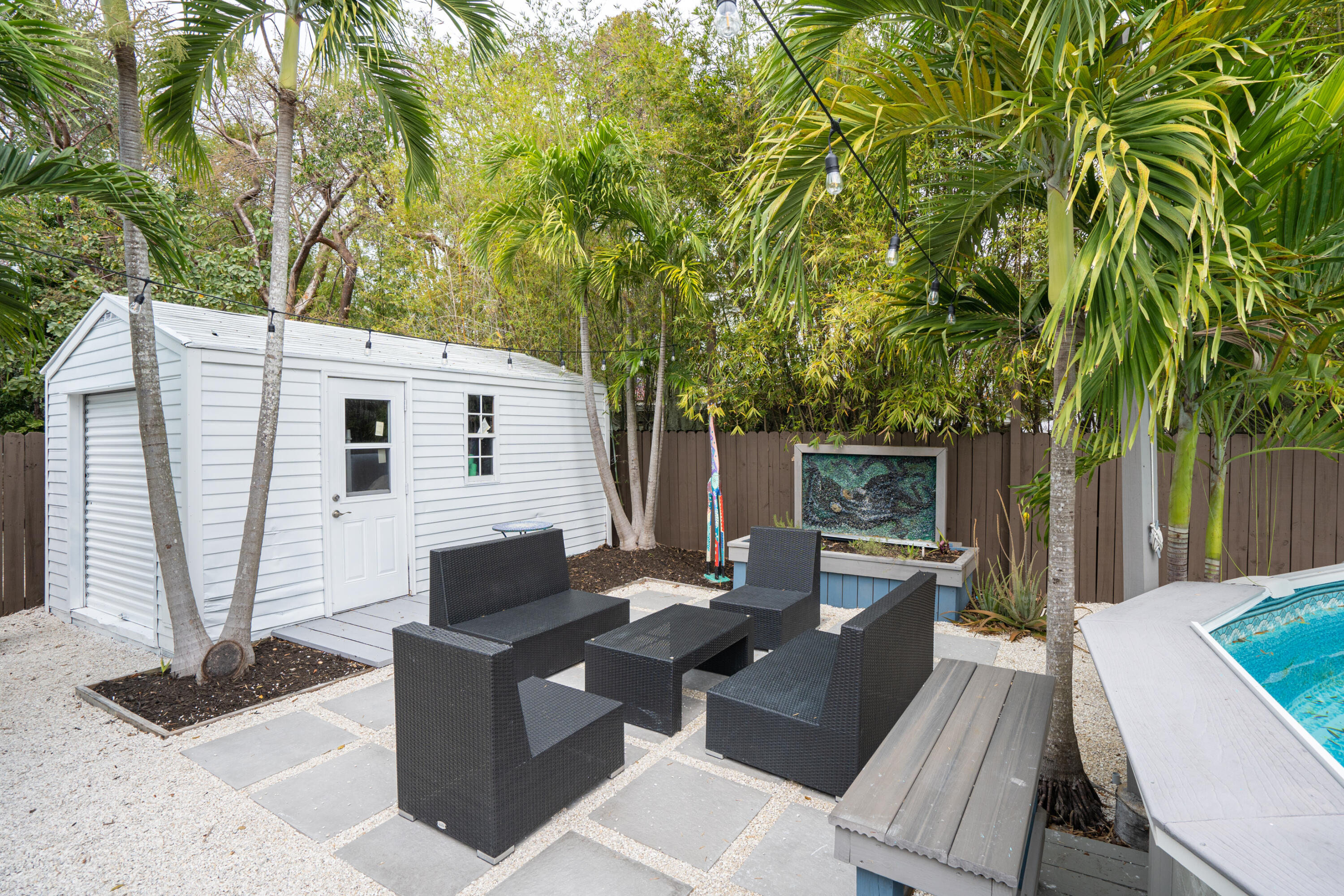 124 South Bay Harbor Drive Key Largo, FL 33037 - Photo 23 of 28 a view of a patio with a table and chairs next to a yard