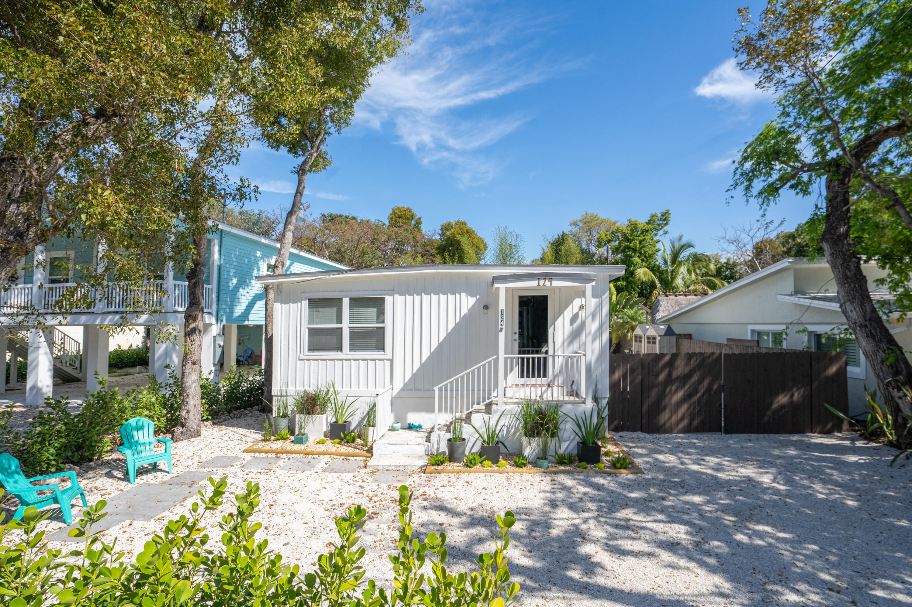 124 South Bay Harbor Drive Key Largo, FL 33037 - Photo 25 of 28 a front view of a house with a yard and potted plants