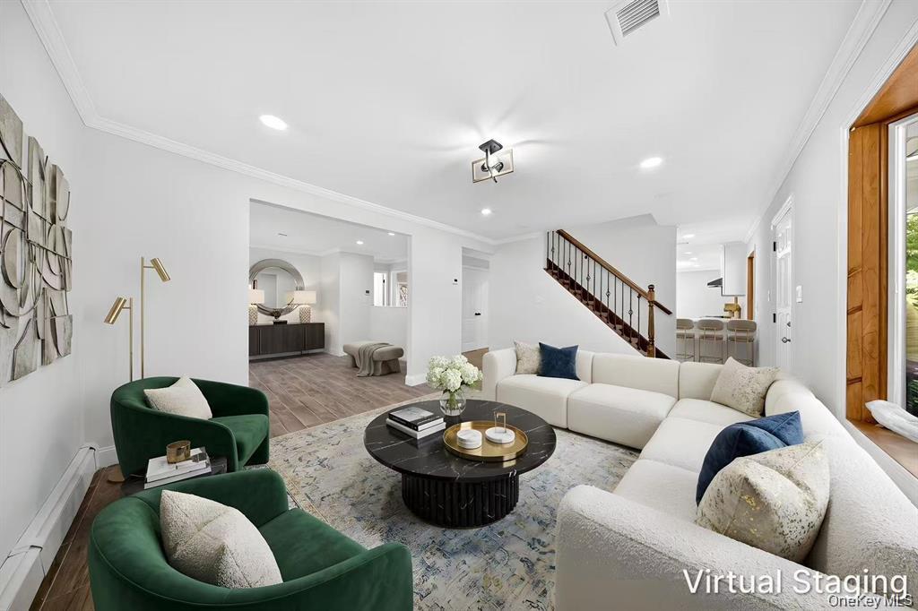 Recessed lighting, crown molding, wood-finish flooring, staircase with wrought iron balusters, and a contemporary ceiling fixture
