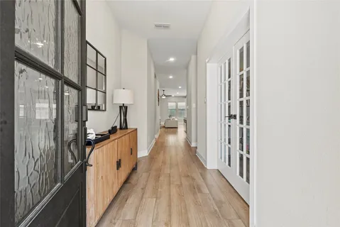 a view of a hallway with wooden floor and staircase