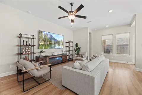 a living room with furniture and a large window with wooden floor