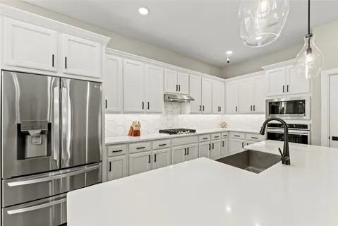 a kitchen with white cabinets and stainless steel appliances