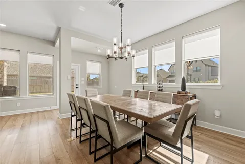 a dining room with furniture a chandelier and wooden floor