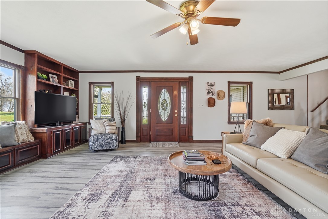 7553 Coffin Station Road Springfield, OH 45502 - Photo 22 of 95 This inviting living space features elegant wood flooring, built-in shelving, and a decorative front door.