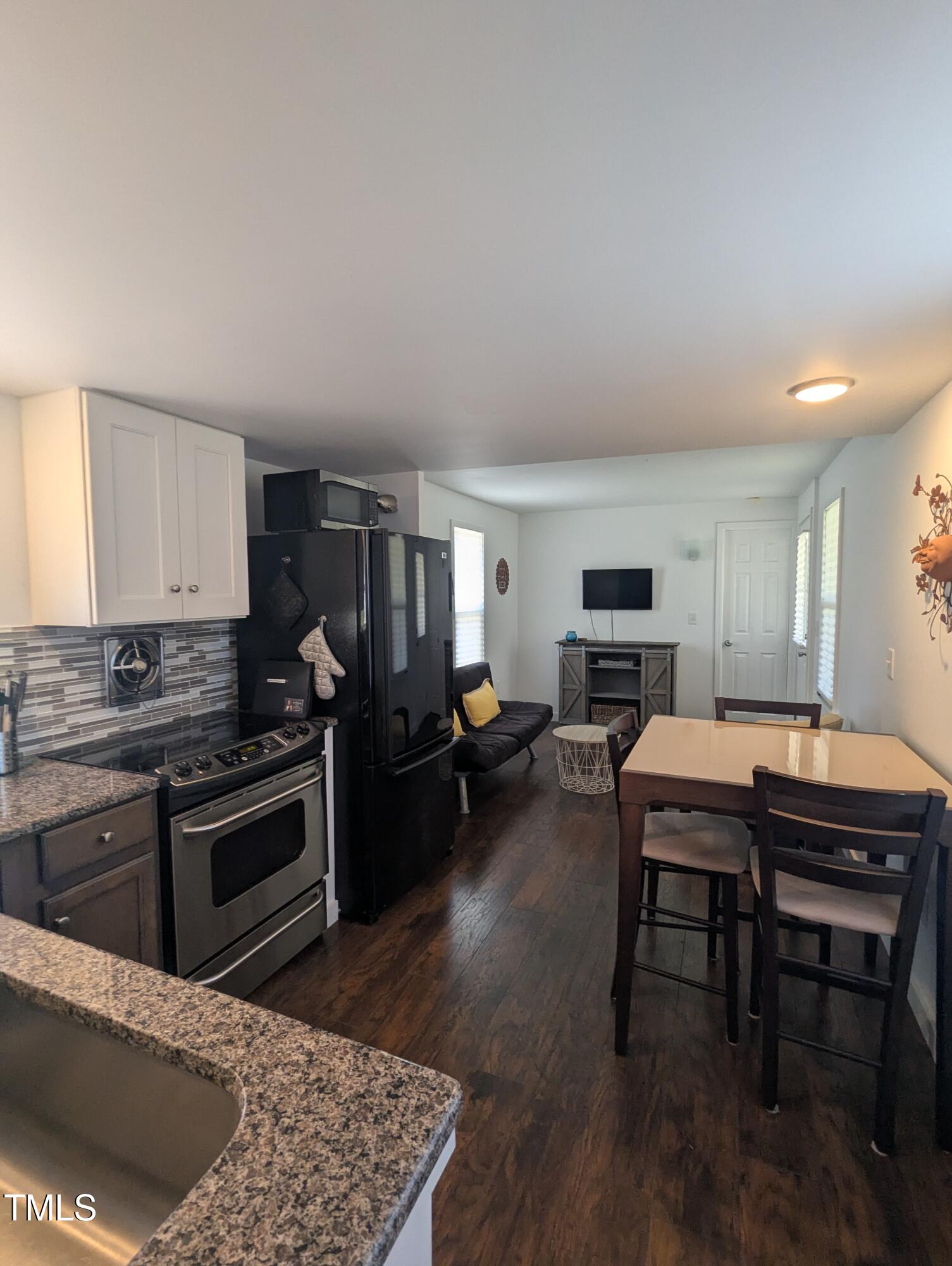 529 Flanagan Road Henderson, NC 27537 - Photo 16 of 38 a kitchen with kitchen island a stove a table and chairs in it